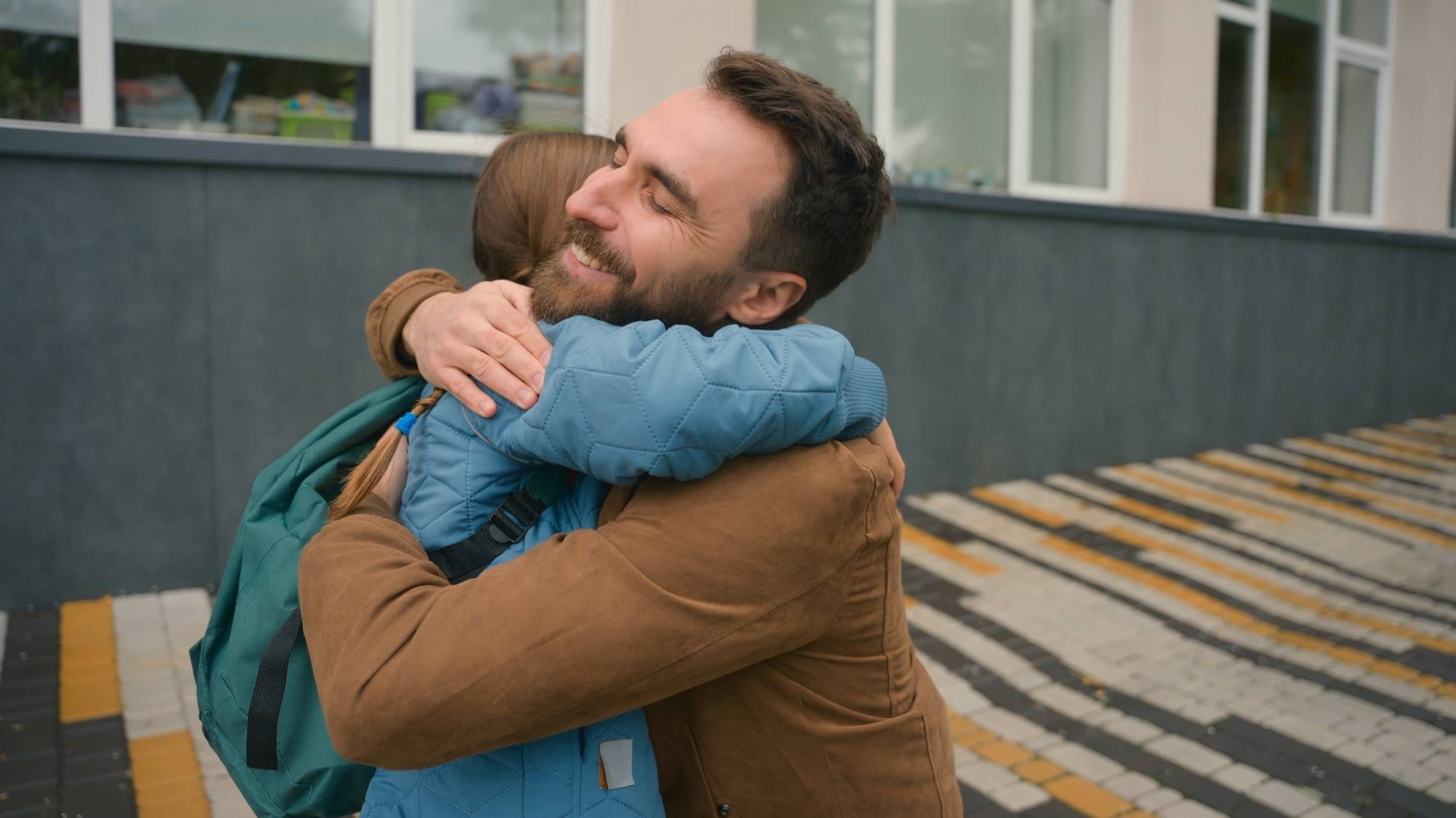 Dad pick up daughter after lessons schoolgirl with backpack elementary school parenting child care