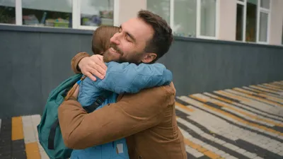 Dad pick up daughter after lessons schoolgirl with backpack elementary school parenting child care